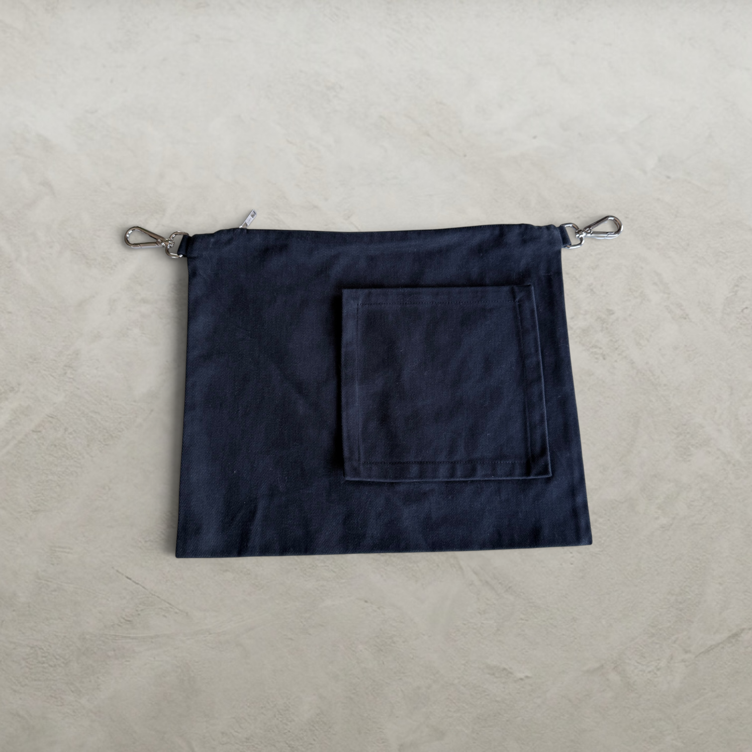 Front view of the PINTO HERVIA Frame Pouch in black cotton drill with oversized square external pocket.
