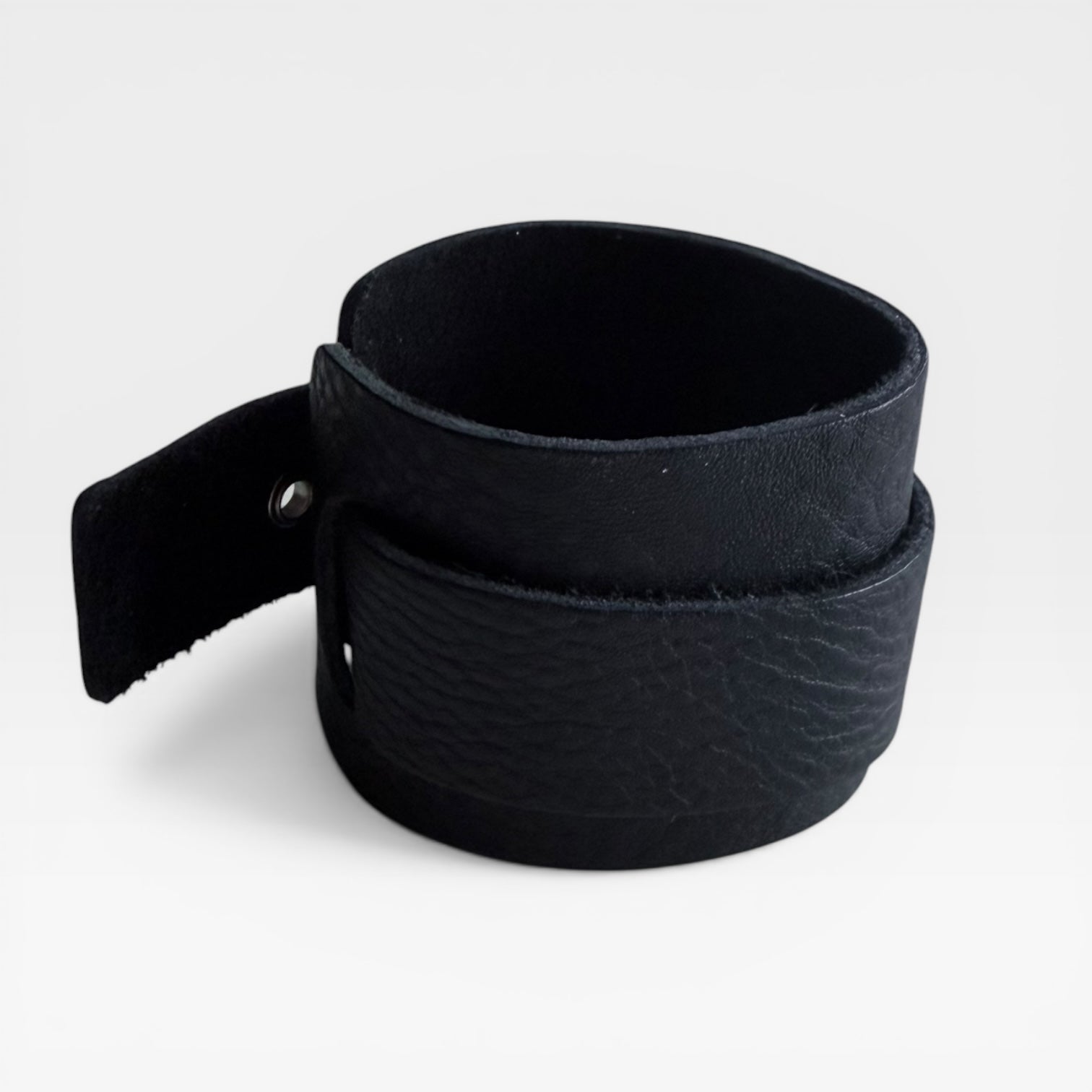 Arc Cuff - Black, leather cuff bracelet made in England, showcasing its curved form and minimal closure.