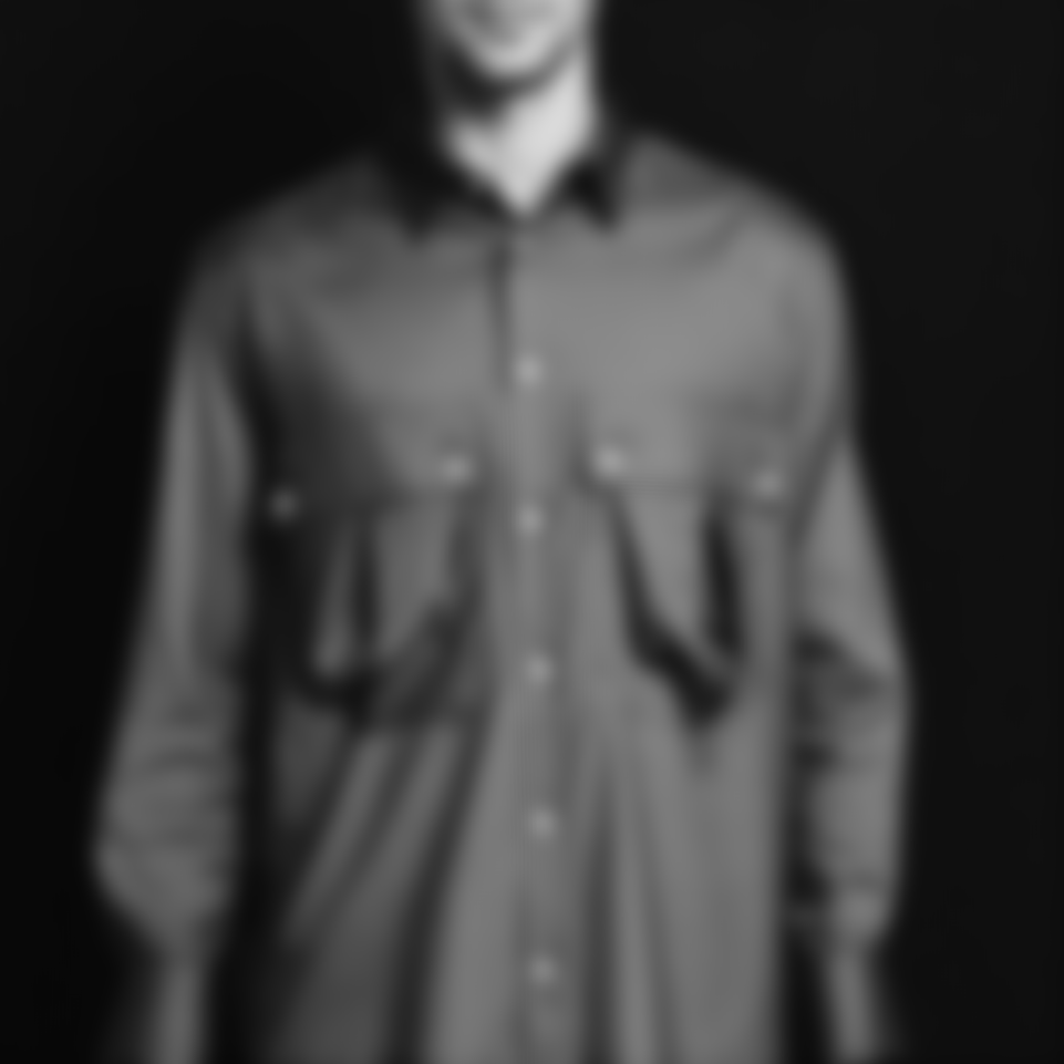 Front view of a blurred navy silk shirt on a mannequin, photographed against a dark background.