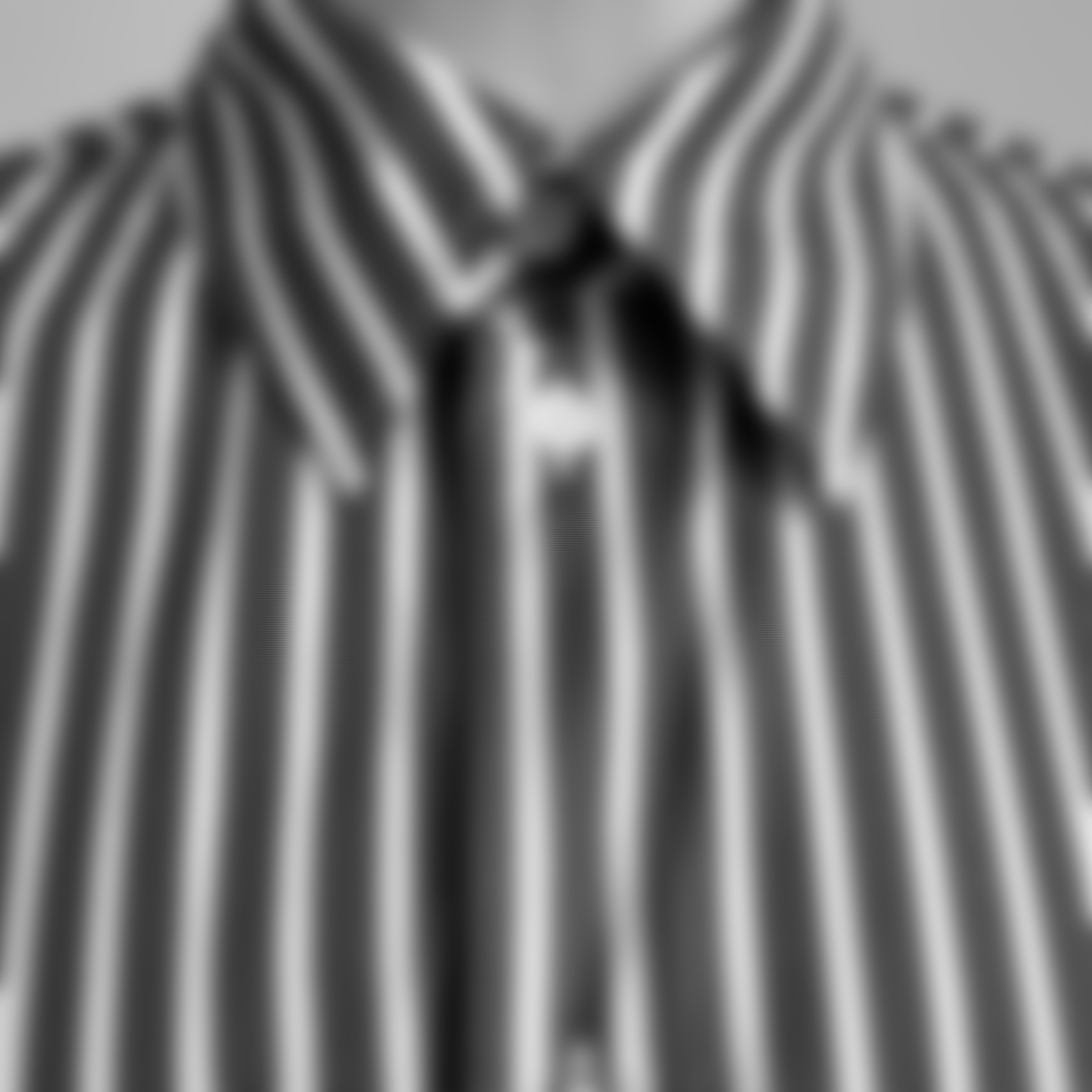 Blurred close-up of a striped button-up shirt collar in monochrome.