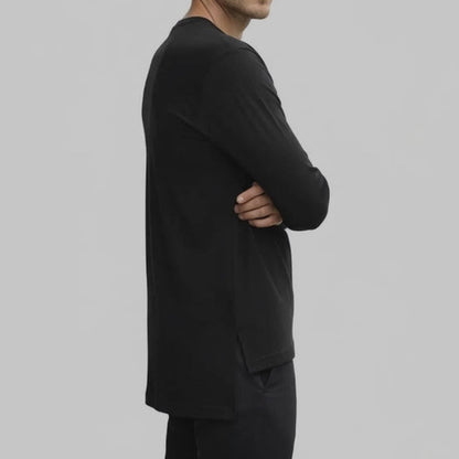 Side view of black long sleeve jersey top showing extended back length and split hem