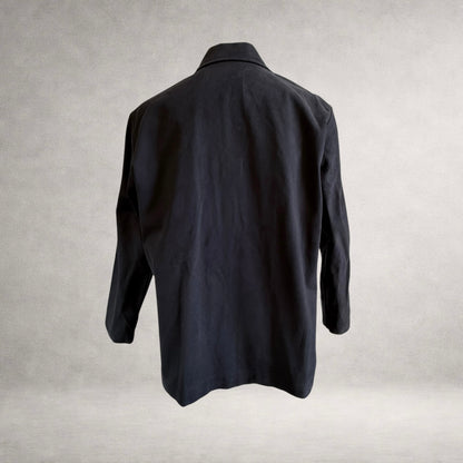 Back view of the PINTO HERVIA Frame Jacket in black cotton drill with relaxed silhouette and clean rear