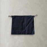 Back view of the PINTO HERVIA Frame Pouch in black cotton drill with detachable silver clip hardware.