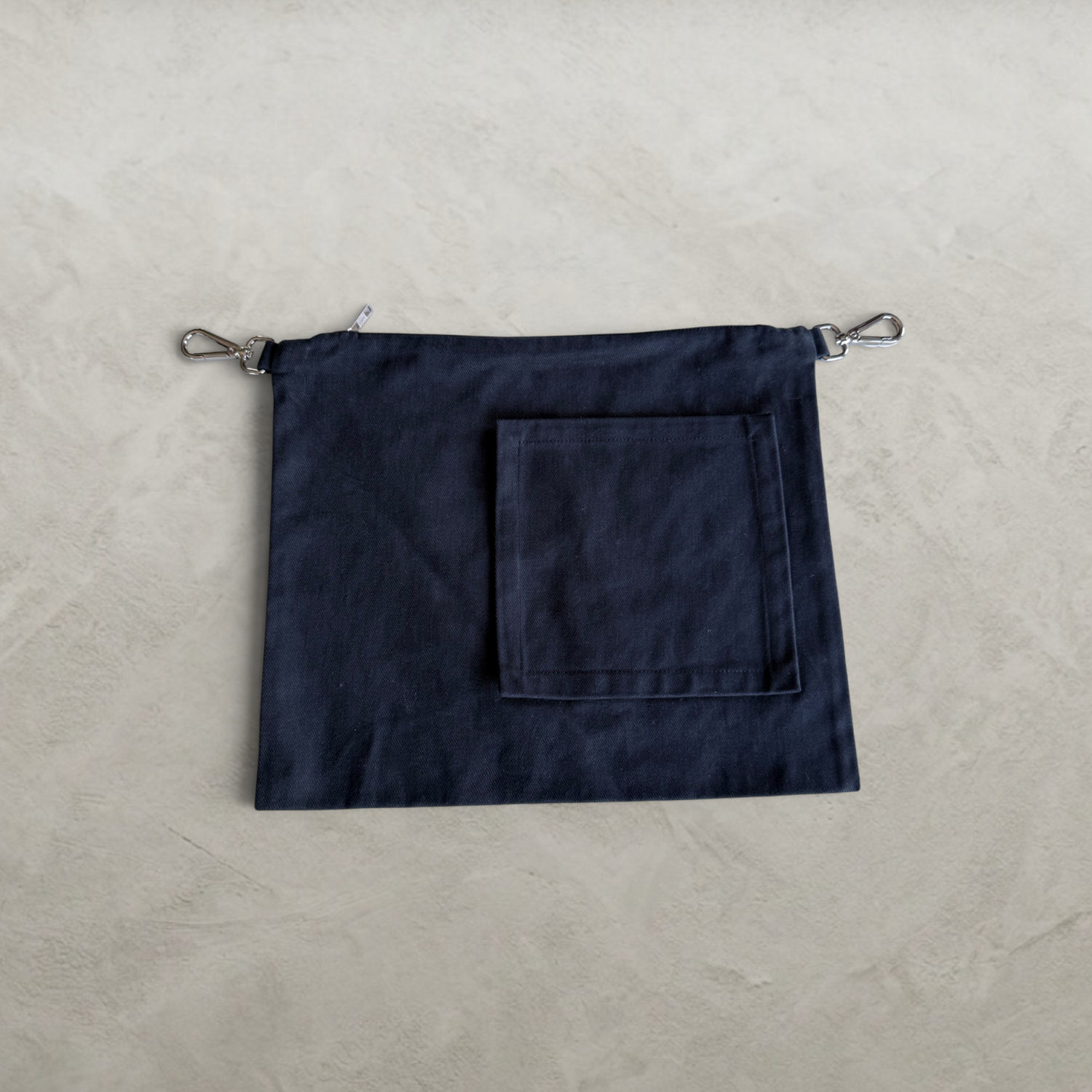 Front view of the PINTO HERVIA Frame Pouch in black cotton drill with oversized square external pocket.