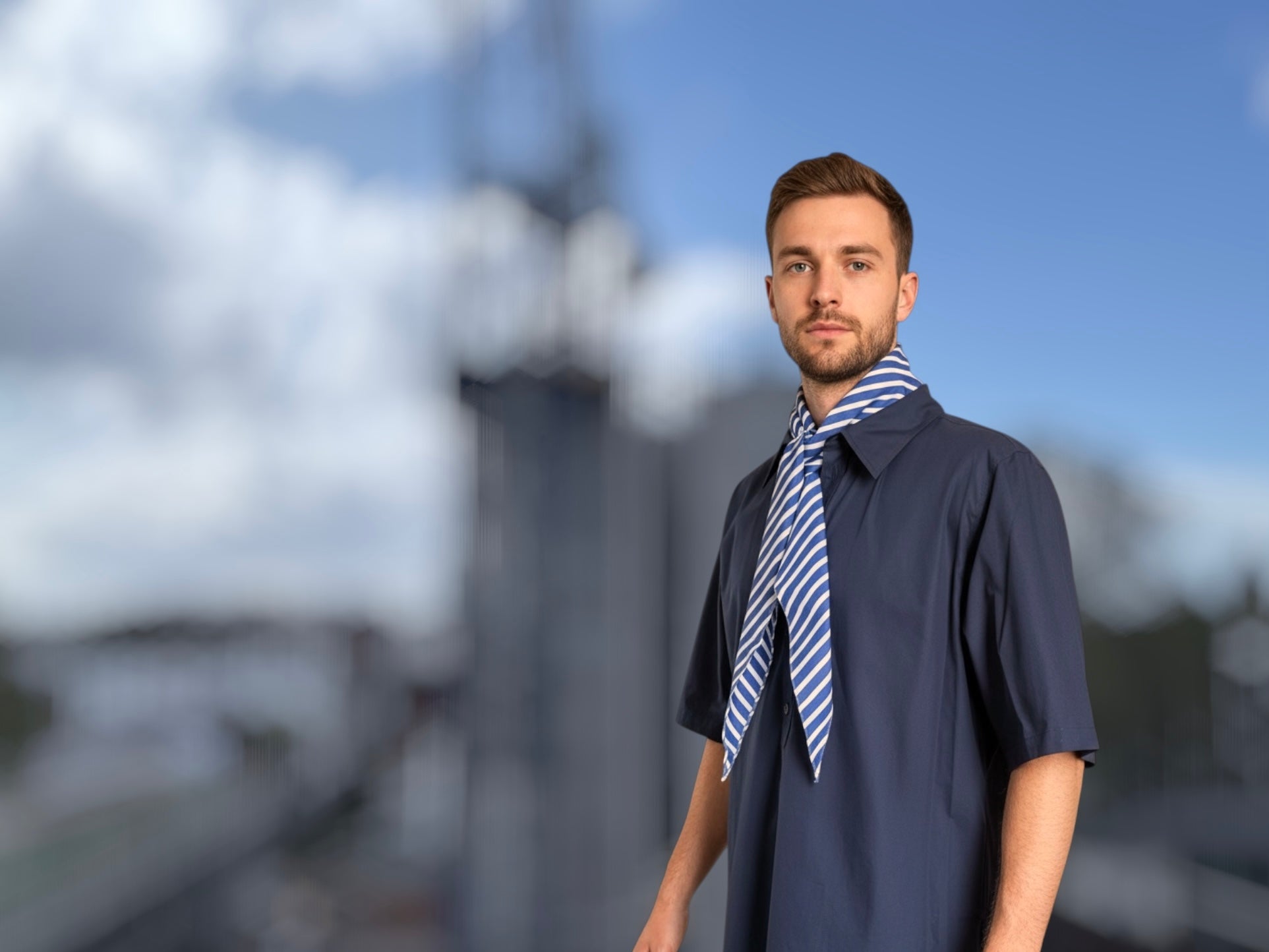 Navy short sleeve shirt with blue striped scarf styled at the neck, refined utility design made in England
