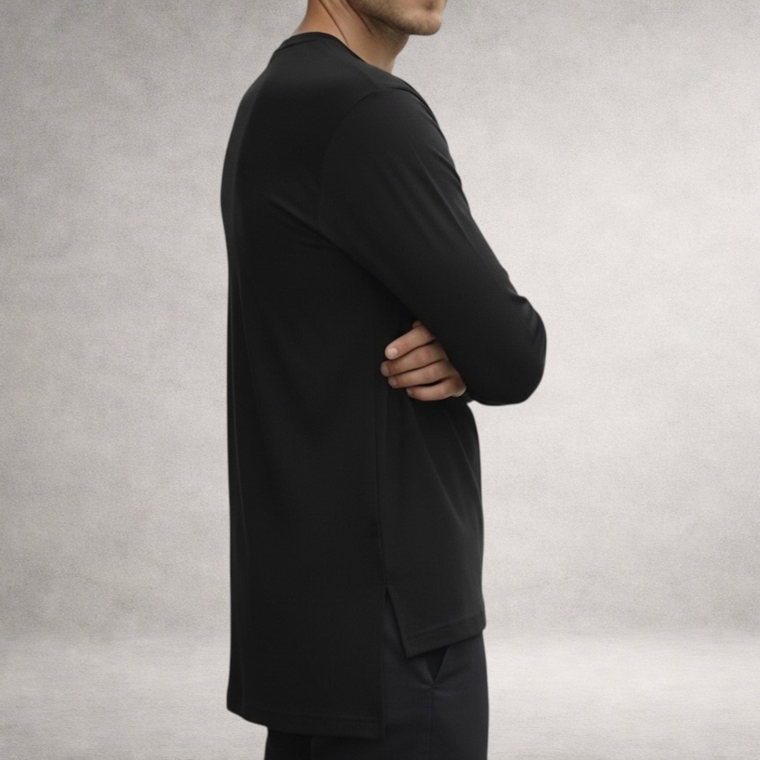 Black Atlas long sleeve top in jersey cotton, side view showing extended back length and split hem